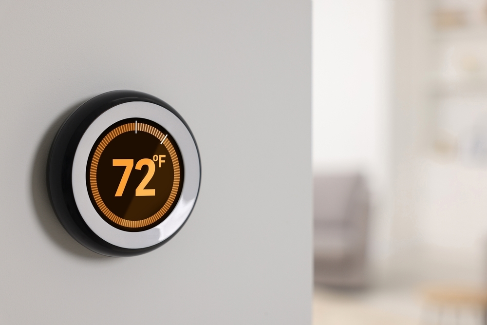 Smart thermostat on a wall displaying 72°F, showing a modern, minimalist design.
